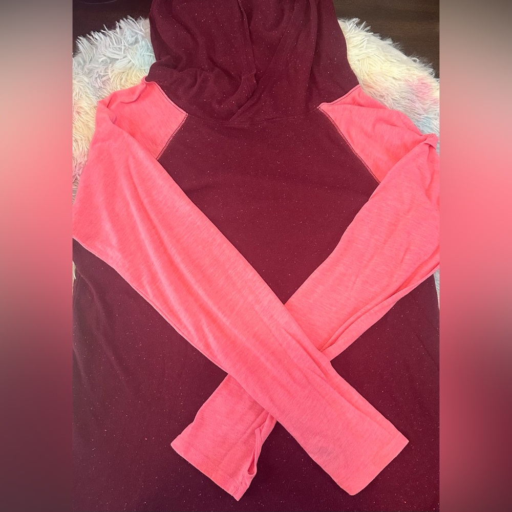 Burgundy and pink hoodie with hood and thumb holes.